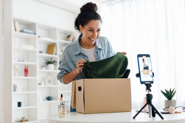 Blogueur femelle faisant la boîte de déballage vidéo avec de nouveaux vêtements à l'intérieur — Photo