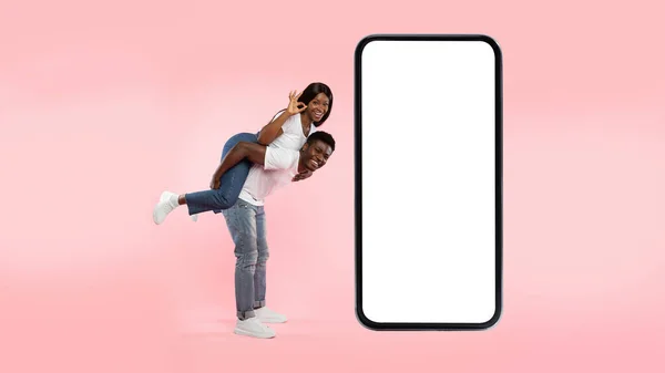Casal mostrando branco tela do smartphone vazio e gesto ok — Fotografia de Stock