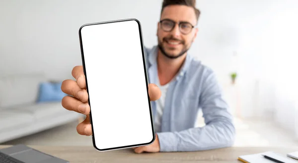Çevrimiçi reklam. Gülümseyen Genç Adam Evde Boş Ekranla Akıllı Telefon Gösteriyor — Stok fotoğraf
