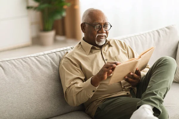 熟女黒人男性読書自宅で座ってリラックス本 — ストック写真