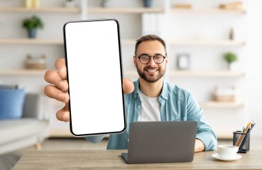 Mobil Teklif. Genç Adam Ofiste Otururken Büyük Boş Akıllı Telefonu Gösteriyor