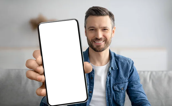 Telefon-Attrappe. Schöner lächelnder Mann zeigt großes leeres Smartphone vor Kamera — Stockfoto