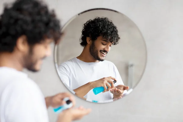 Joven hombre indio aplicando espuma de afeitar de pie en el baño moderno y preparándose para la rutina de afeitado por la mañana — Foto de Stock