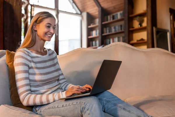 Lächelnde Frau arbeitet zu Hause am Laptop — Stockfoto