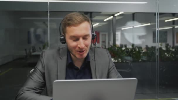 Suporte técnico aos clientes. Jovem operador de linha de ajuda no fone de ouvido conversando com o cliente, consultoria sobre solução de problemas — Vídeo de Stock