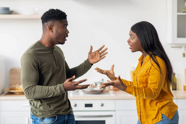 Conflitos domésticos. Jovens negros cônjuges argumentando na cozinha, sofrendo problemas de relacionamento — Fotografia de Stock