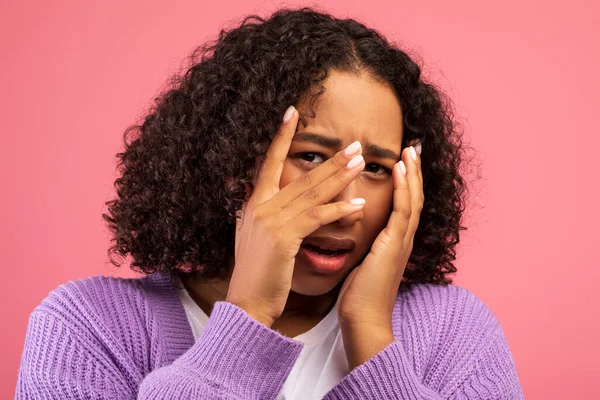 Conceito de emoções humanas negativas. Jovem negra sentindo medo, cobrindo seu rosto em pânico no fundo do estúdio rosa — Fotografia de Stock