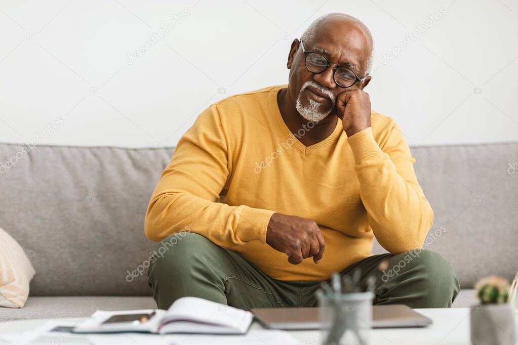 Mature African American Man Sitting On Couch At Home