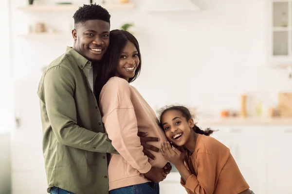 Família afro-americana feliz esperando bebê em pé na cozinha interior — Fotografia de Stock