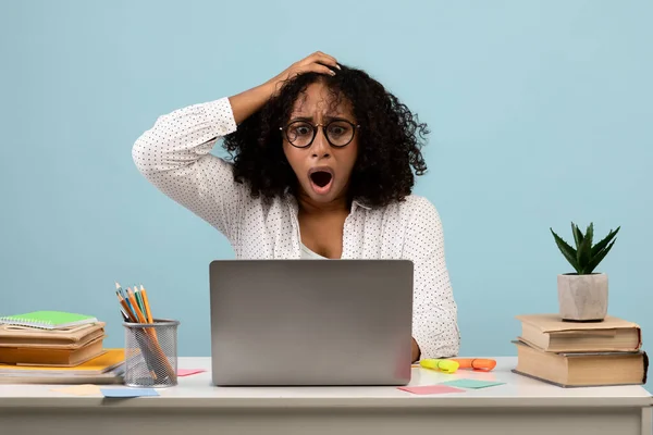 Deadline Konzept. Schockierte schwarze Frau sitzt mit Laptop am Schreibtisch und fasst sich an den Kopf, studiert oder arbeitet — Stockfoto