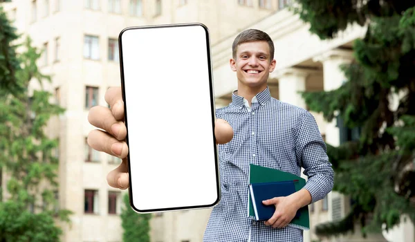 Estudiante masculino mostrando pantalla blanca vacía del teléfono inteligente, primer plano — Foto de Stock