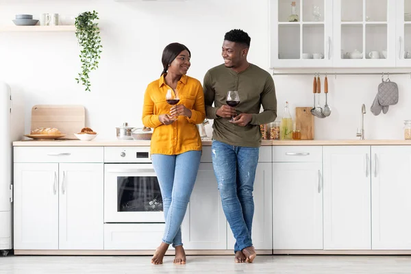 Romantisches schwarzes Paar trinkt gemeinsam Rotwein in der Küche und feiert den Valentinstag — Stockfoto