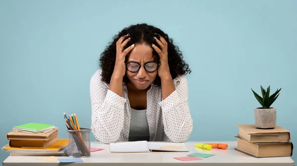 Moe Afro-Amerikaanse vrouwelijke student huilen over boeken en notitieboekjes, studeren voor moeilijke examen op blauwe achtergrond — Stockfoto