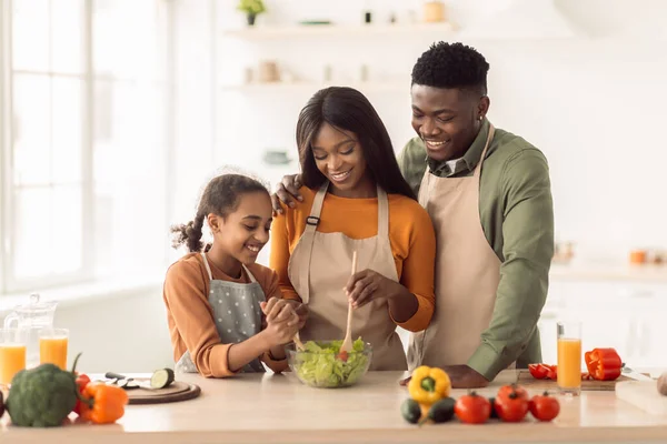 Familia negra cocinando haciendo ensalada preparando la cena en la cocina — Foto de Stock