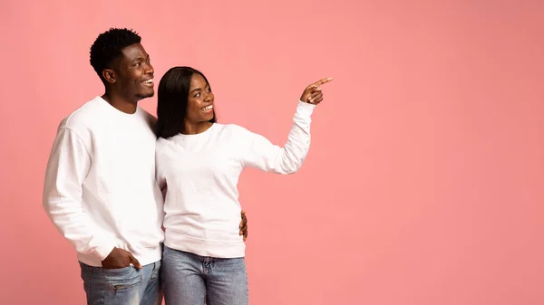 Älskande afrikansk amerikansk par omfamna och peka på kopia utrymme — Stockfoto