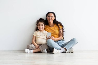 Mobil Teklif. Genç Arap Kadın ve Akıllı Telefonlu Küçük Kızı