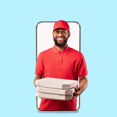 Üniformalı neşeli siyahi teslimatçı büyük telefon ekranından bir sürü pizza veriyor.