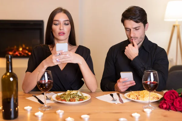 Unhappy Couple Using Mobile Phones Bored On Date