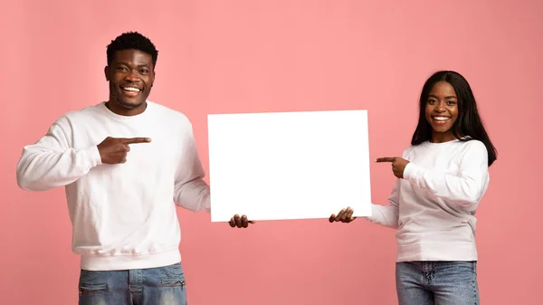 Šťastný černošky pár ukazuje na reklamní tabuli v jejich rukou — Stock fotografie