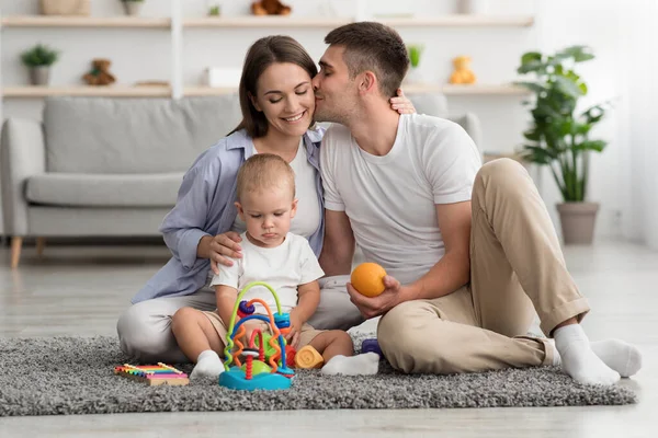 Gelukkige jonge familie. Liefdevolle ouders en weinig kind ontspannen in huis Interieur — Stockfoto