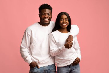 Güzel Afro-Amerikalı aşıklar pembe elbiseli benzer kıyafetler giyiyorlar.