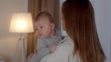 Çocuk bakımı konsepti. Sevecen anne kucağına alıp kucağına alıyor.