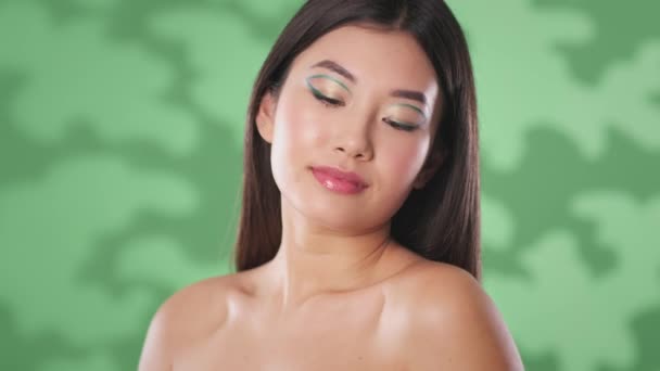 Natural beauty and organic cosmetics. Young shirtless asian lady posing with monstera leaf, stroking her body — Stock Video