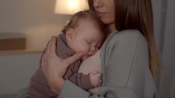 Nahaufnahme eines entzückenden neugeborenen Babys, das friedlich auf der Brust seiner Mutter schläft — Stockvideo