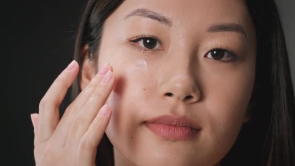 Concept hydratant pour la peau. Jeune femme asiatique appliquant de la crème nourrissante sur sa région sous les yeux, procédures de levage de la peau — Video