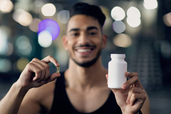 Fitness Supplementen. Sportieve Midden-Oosten Guy demonstreren witte pot en capsule pil — Stockfoto
