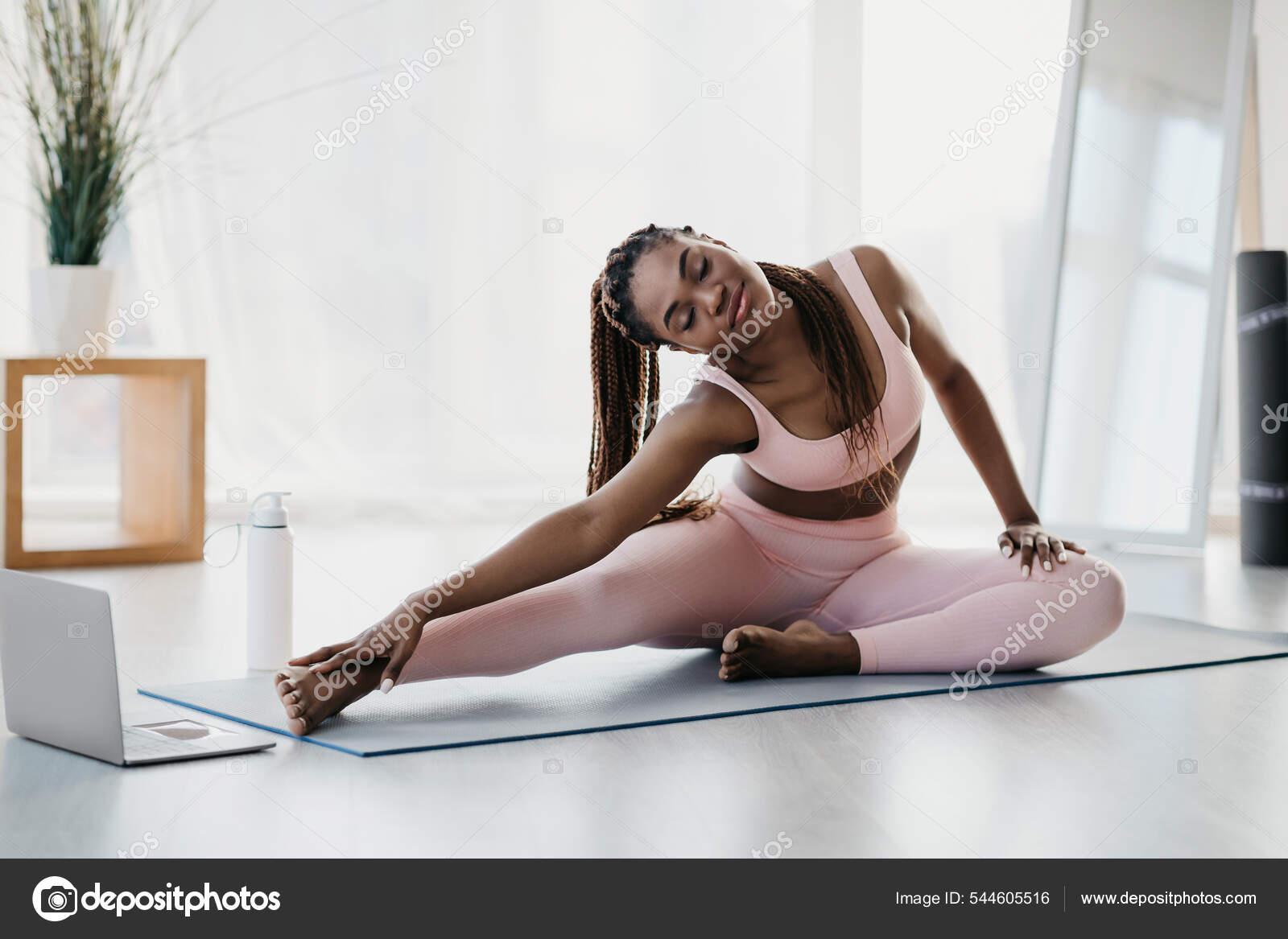 Young black woman stretching near laptop on domestic training, practicing  yoga or pilates at home, copy space Stock Photo by ©Milkos 544605516