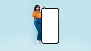 Siyah kadın beyaz, boş akıllı telefon ekranı gösteriyor