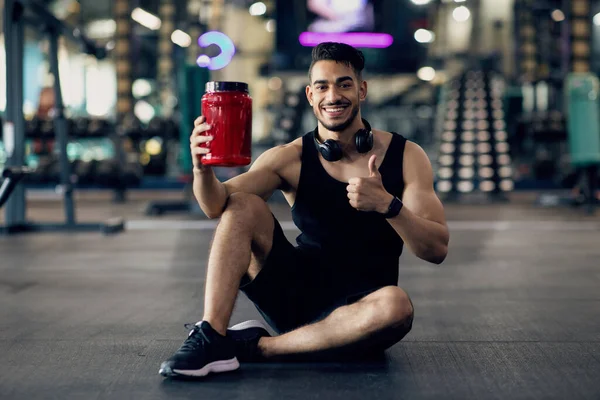 Handsome Muscular Middle Eastern Guy Advertising Fitness Supplements While Posing At Gym — Stock Photo, Image