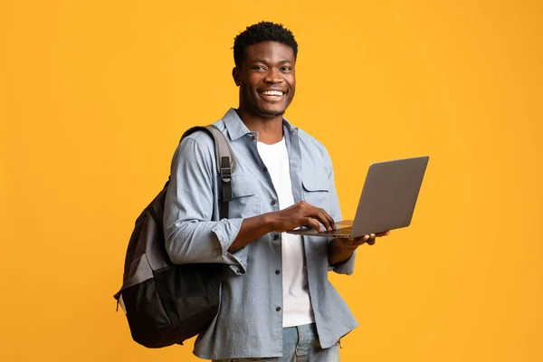 Joyeux étudiant afro-américain masculin utilisant un ordinateur portable — Photo