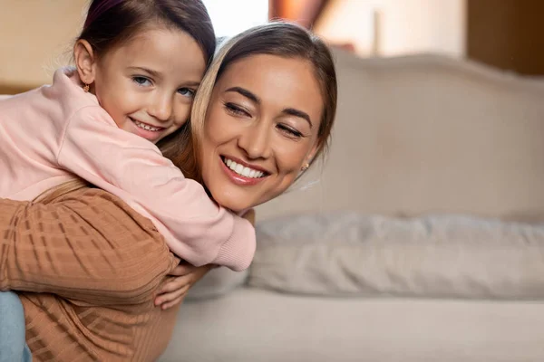 Retrato de mujer feliz e hija abrazándose en casa —  Fotos de Stock