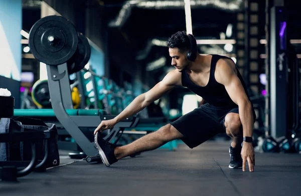 Guapo joven Oriente Medio atleta masculino calentándose antes de entrenar en el gimnasio —  Fotos de Stock