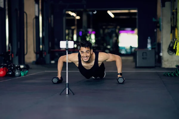Athletic Arab Man Making Dumbbell Push-Ups While Recording Content On Smartphone Camera — Stock Photo, Image