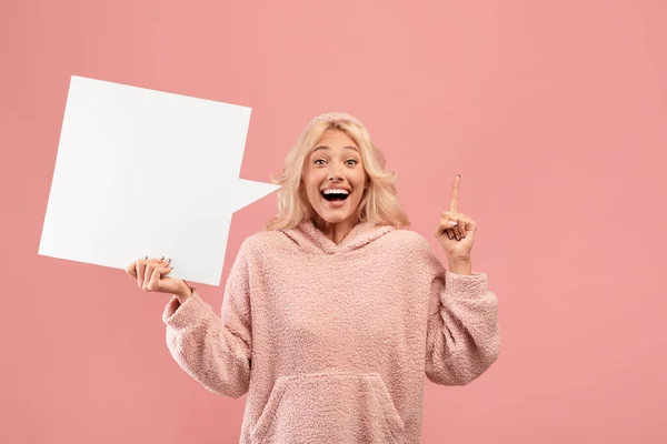 Ideenkonzept. Inspirierte aufgeregte Frau mit Idee, mit leerer Sprechblase und erhobenem Zeigefinger, rosa Hintergrund — Stockfoto