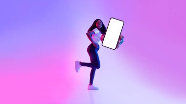 Cep telefonu ekran modeli. Neşeli genç siyahi kadın boş cep telefonuyla koşuyor, neon ışıkta yeni uygulamayı tanıtıyor