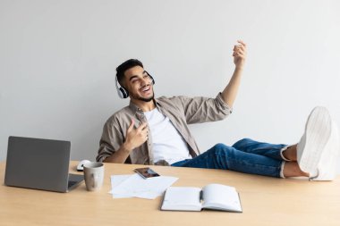 Gülümseyen Arap arkana yaslanıp sanal gitar çalıyor.