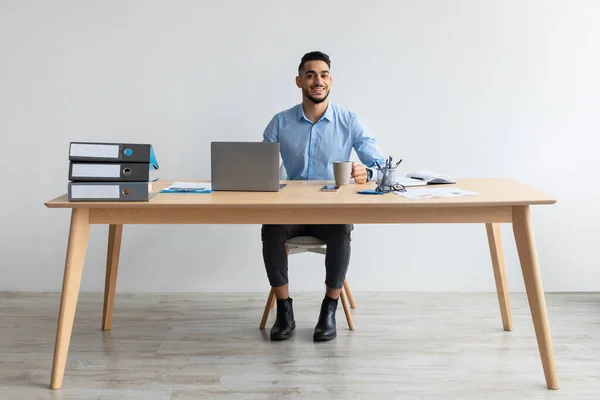 Ritratto di uomo arabo sorridente che usa il computer portatile e posa — Foto Stock