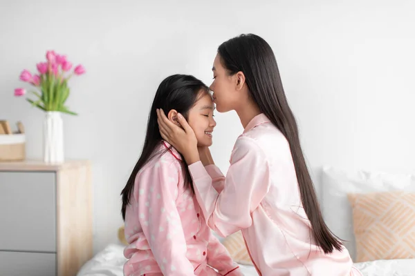 Allegro giapponese millenario femminile baciare sulla fronte di ragazza adolescente in camera da letto interno, profilo, spazio libero — Foto Stock