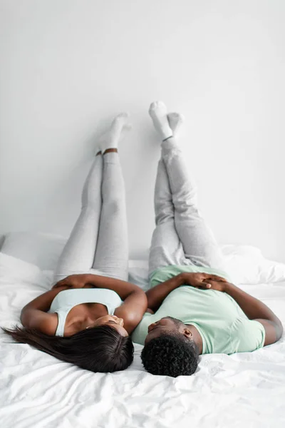 Fericit tânăr afro-american soț și soție pus picioare pe perete alb bucurați-vă de moment tandru la timp liber — Fotografie, imagine de stoc