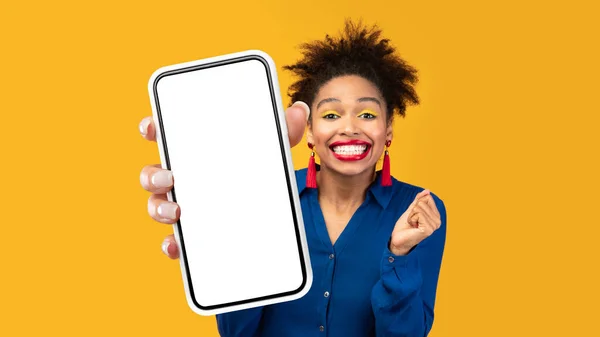 Joyful Black Lady mostrando grande Smartphone tela vazia, fundo amarelo — Fotografia de Stock