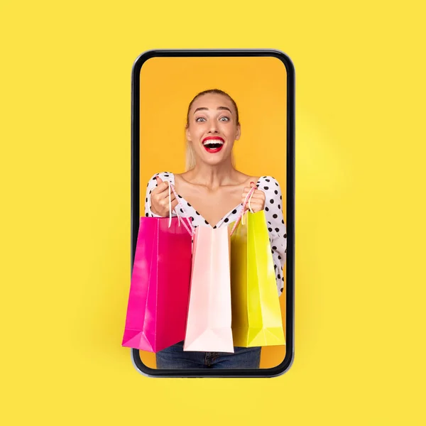 Nő Smartphone Screen holding Bevásárlótáska felett sárga háttér — Stock Fotó