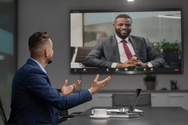 Moyen-Orient homme d'affaires ayant une vidéoconférence avec PDG noir — Photo