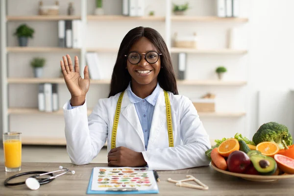 Ritratto di felice nutrizionista afro-americano che dà consulenze online ai pazienti, con videochiamata in clinica — Foto Stock