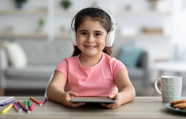 Crianças e Gadgets. Menina pré-adolescente bonito em fones de ouvido sem fio usando tablet digital — Fotografia de Stock