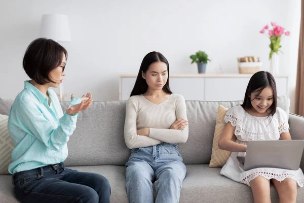 Ofendido jovem mulher asiática ter briga com sua mãe madura sobre meninas vício gadget em casa — Fotografia de Stock