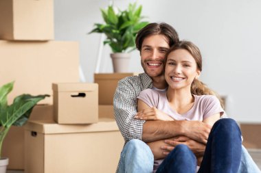 Neşeli bin yıllık beyaz adam kadınlara sarılıyor. Kutuların, bitkilerin, eşyaların arasında oturuyor.